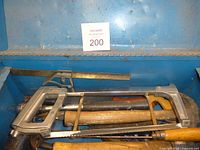 View of blue toolbox drawer showing hacksaw, hammer, files, pliers