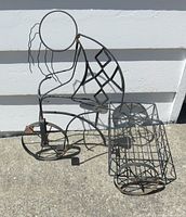 Overall view of metal tricycle plant stand with basket