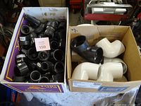 Two boxes of fittings: left full of black couplings/adapters, right with white and one black elbows