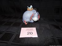 Front view of Disney Eeyore ceramic figurine with auction tag
