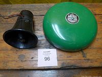 Green N-CO Bell and black siren on table
