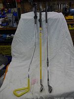 Three golf training clubs leaning against backdrop showing full length