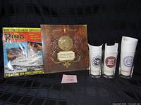Group shot of magazine, program, three logo glasses and one plain glass