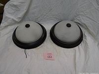 Pair of ceiling lights showing glass domes and bronze rims
