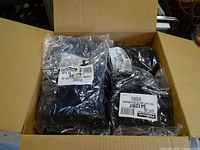 Open carton showing multiple sealed bags of black tee connectors