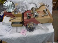 All boxed Price Pfister faucet components laid out: showerhead, spout, handles, boxes visible
