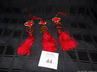 Three red tassel Buddha Chinese knot ornaments displayed