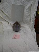 Entire lamp with shade displayed against cloth backdrop