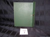 Closed green stamp album standing upright
