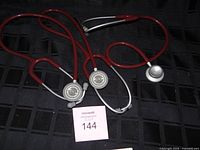 Three stethoscopes laid out to show tubing and chestpieces