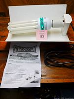 Grow light on white backdrop with instruction manual and lot card
