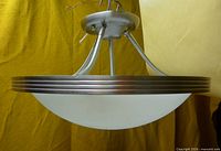 Side view showing brushed nickel frame and white glass shade