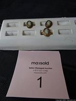 Ring and earrings on display tray, frontal view