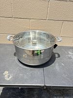 Stainless steel stock pot with lid on table