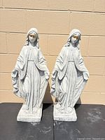 Front view showing both Virgin Mary statues on bases