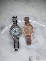 Front view of both watches with dials and bracelets visible