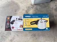 Retail boxes of Mirro 4 qt and Philippe Richard 4 qt aluminum pressure cookers side-by-side