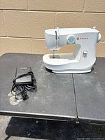 Singer M1500 sewing machine with foot pedal on table