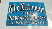 Front view of blue enameled metal sign with The Nationale Fire Insurance Company of Paris, France text