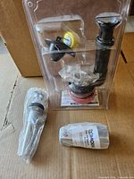 Overall view of packaged Moen spout, drain assembly and hardware