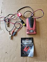 Inverter with both connection cables and manual on cardboard surface