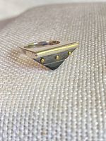 Ring perspective view showing triangular top with wood inset and gold-tone studs