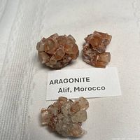 Three aragonite clusters with identification card