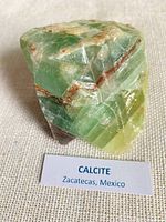 Front view of banded calcite specimen with label