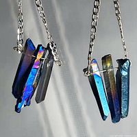 Close-up of both aura quartz earrings showing crystal coloration and silver chains