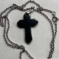 Hematite cross pendant with chain coiled