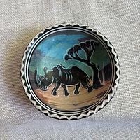 Top view of painted soapstone dish showing rhinoceros scene and rim pattern