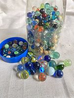 Jar of mixed marbles with some displayed outside