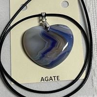Front view of heart-shaped banded agate pendant on black cord