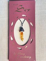 Boxed presentation of perfume necklace showing packaging text Beyond Sex and vial