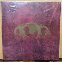 Front gatefold sleeve showing burgundy cover with gold embossed oval Beatles silhouette