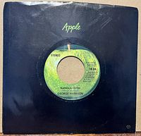 Front view of 7-inch single in black Apple company sleeve, label side showing
