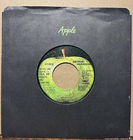 Record in black Apple sleeve showing A-side label