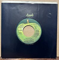 Front view of record in black Apple sleeve, label visible through center cut
