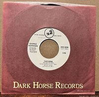Front view of record inside Dark Horse Records sleeve showing label through center hole