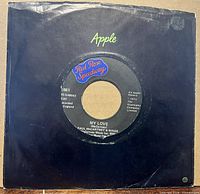 Front view of 45 rpm record partially in black Apple sleeve