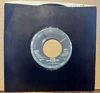 Record in black stock sleeve, label partially visible