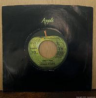 Record in black Apple sleeve showing overall condition