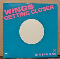 Front of teal picture sleeve with “Wings Getting Closer” text