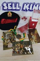 Group shot of cap, medal, flag in bag and several postcards