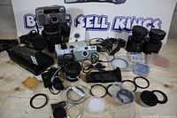 Group shot showing all cameras, filters, caps, pouches, chargers and mount