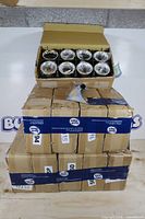 Stack of four cartons, top carton open showing packaged silver-plated cups