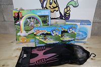 Overall lot showing boxed rainbow arch, two Slip 'N Slides, Intex boat, mesh bag with fins
