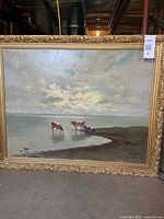 Front view of framed oil painting depicting cows at shoreline