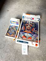 Both tabletop pinball games side by side for size comparison