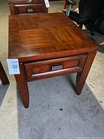 Front view of wooden end table showing drawer